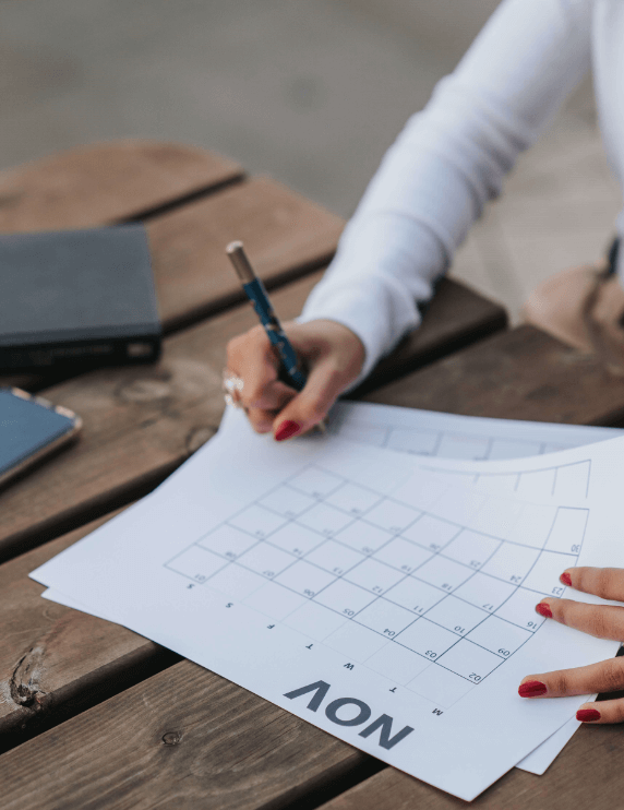 Student planning her study timetable on a calendar.