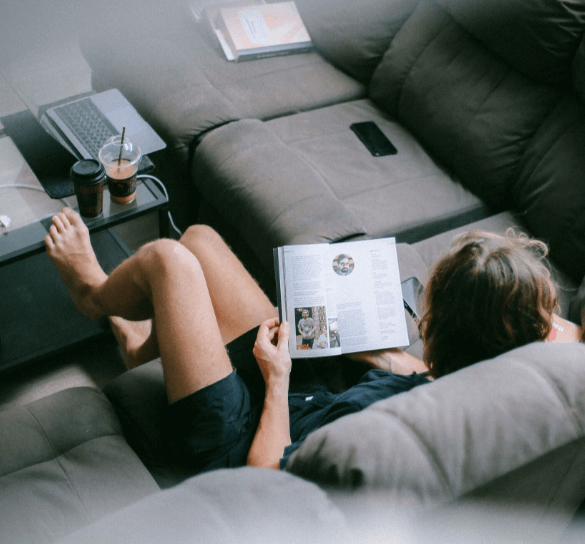 Student reading an English book on the cushion to prepare for IELTS tests.