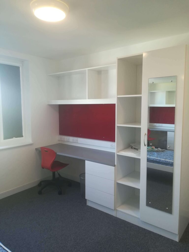 Hostel room in the UK with table and chair.