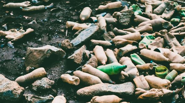 Dirty plastic bottles littered on the beach.