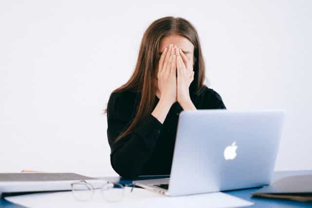 Girl reacting to anxiety with hands covering face.