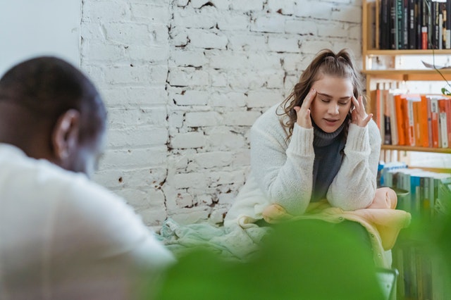 Girl touching her head looking frustrated.