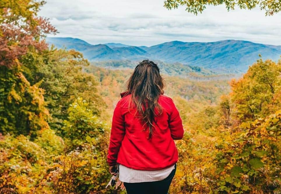 Girl standing on top of mountain looking at the scenery 