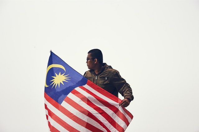 Man holding flag studying law in Malaysia.